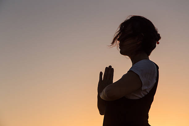 istock Silhouette young woman practicing yoga on the beach at sunset. 480067138