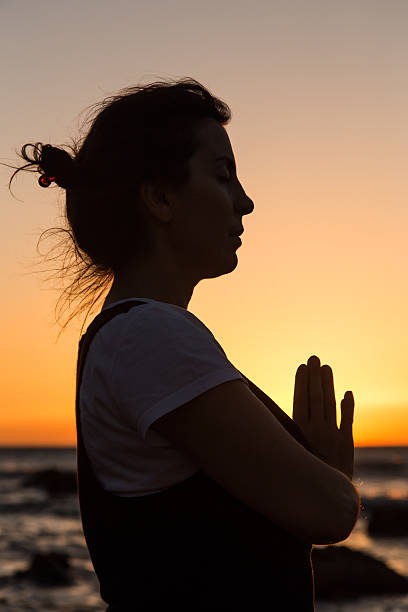 istock Silhouette young woman practicing yoga on the beach at sunset. 480067188