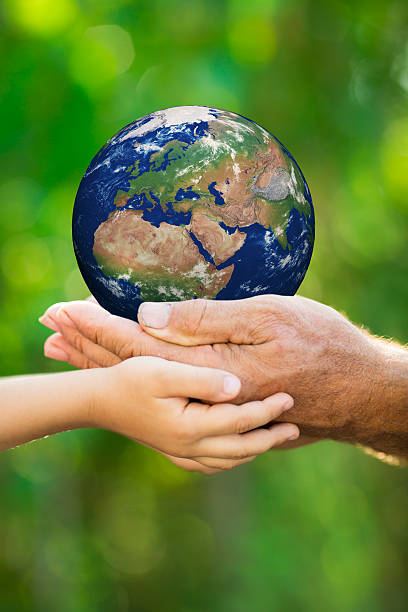 istock Child and man holding Earth in hands 480069529