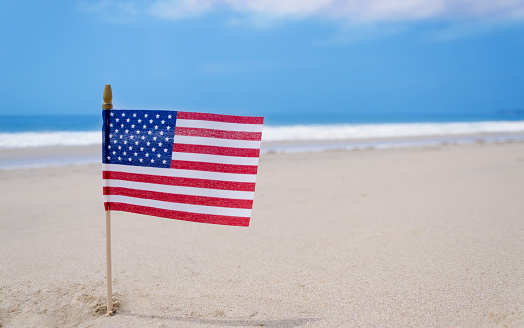 Patriotic USA background with American flag on the sandy beach