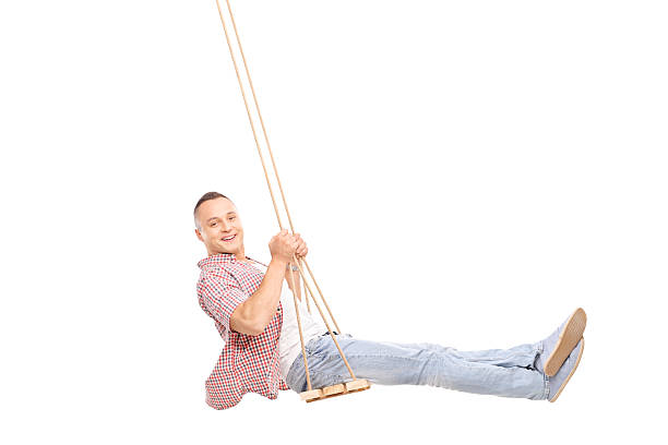 istock Delighted young man swinging on a wooden swing 480072336
