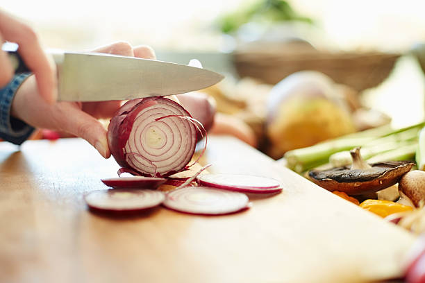 istock Woman chopping onion on cutting board 480075140