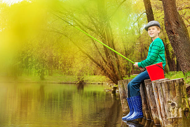 pesca lindo menino perto de lago com fishrod - ticket ticket stub park fun imagens e fotografias de stock