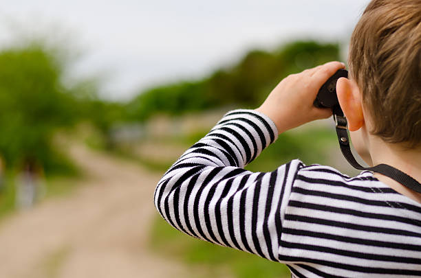 istock Little boy scanning the woods with binoculars 480081412