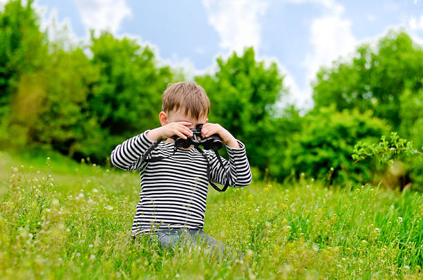 istock Little boy scanning the woods with binoculars 480081424