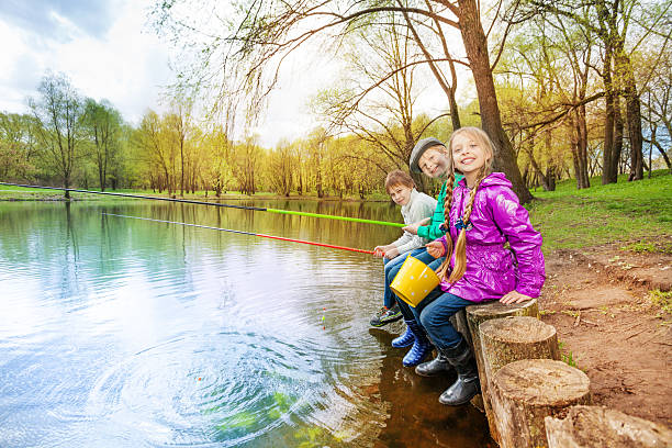 criança sentada perto lago segurando a pesca das entradas mais duras. - ticket ticket stub park fun imagens e fotografias de stock