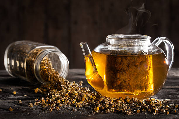 Hot Chamomile Tea in a clear Teapot and Dried Flowers stock photo