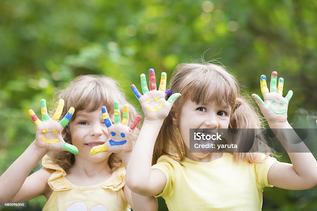 Happy hands Happy child with smiley on hands against green spring background Baby - Human Age Stock Photo