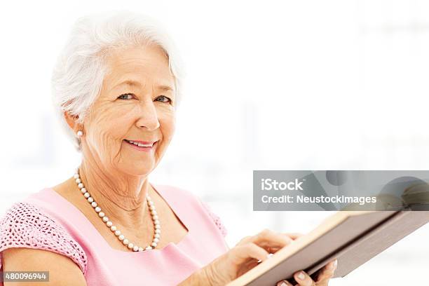 Portrait Of Senior Woman Reading Book Stock Photo - Download Image Now - 2015, 60-64 Years, 60-69 Years