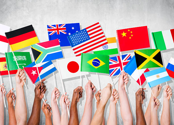 human hands holding national flags - global communications earth human hand globe fotografías e imágenes de stock