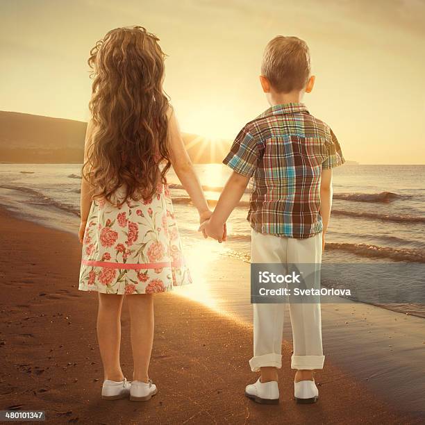 Back View Of Little Kids Holding Hands At Sunset Stock Photo - Download Image Now - Affectionate, Bonding, Boys