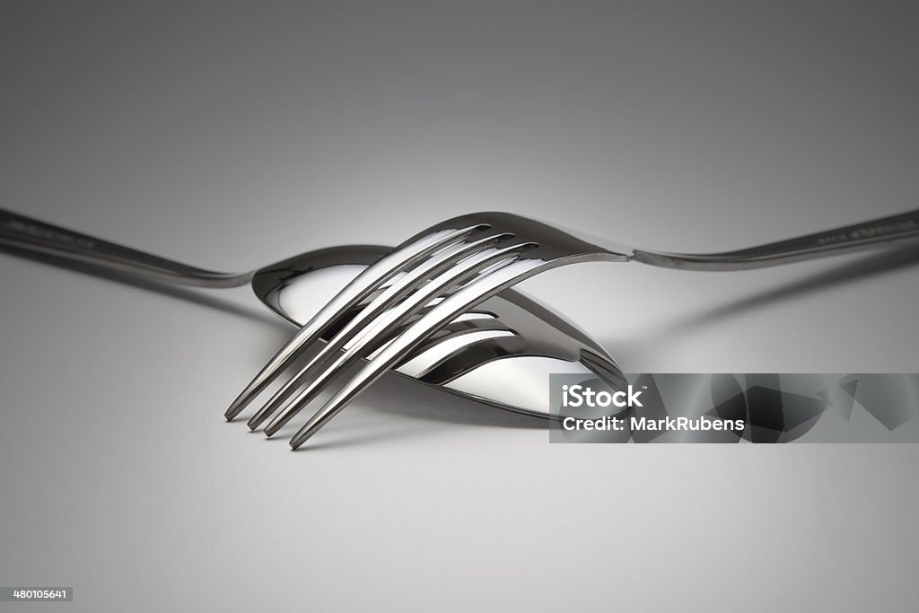 Reflection of a fork on the spoon Tableware collection: Reflection of a fork on the spoon Dark background. Arrangement Stock Photo