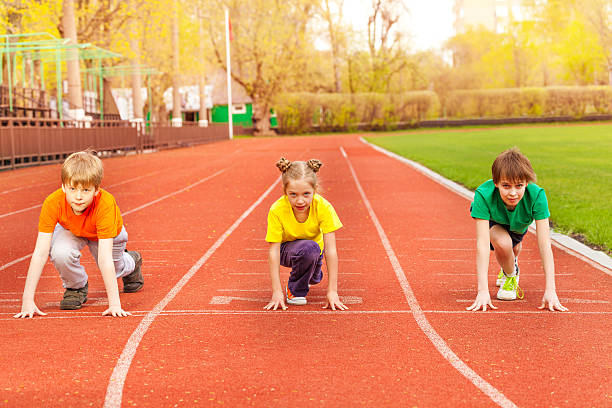 istock Three kids stand with bended knee ready to run 480106346
