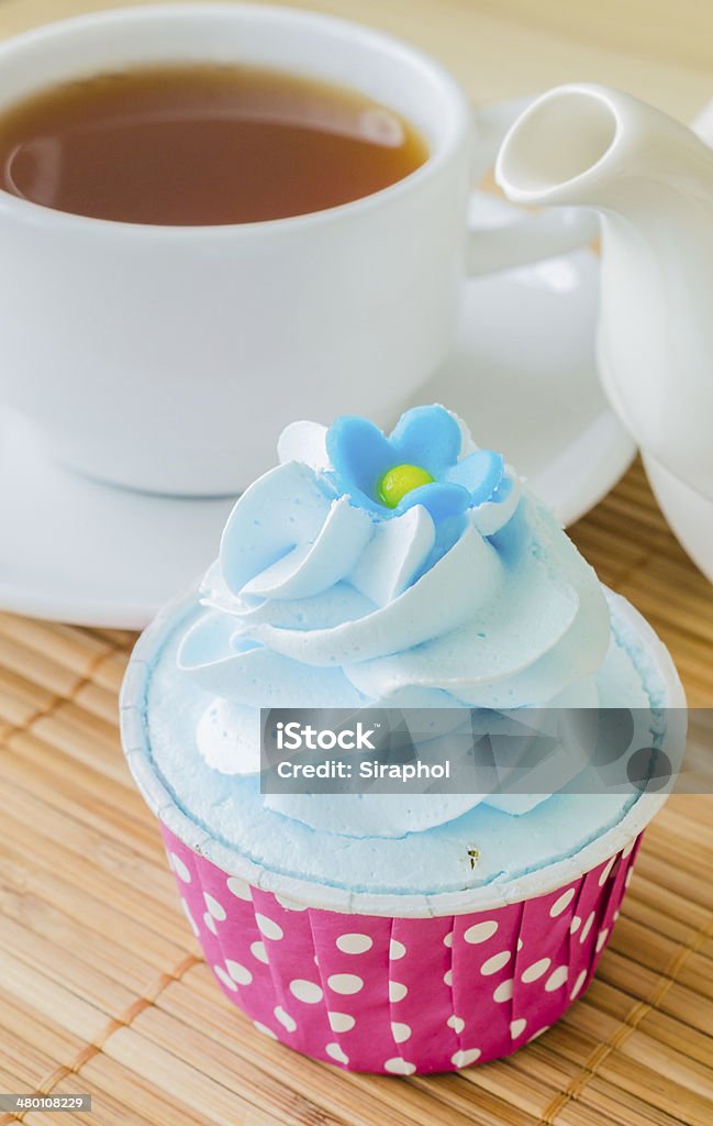 Cupcake Mint cupcake on bamboo table with white tea cup&tea pot Affectionate Stock Photo