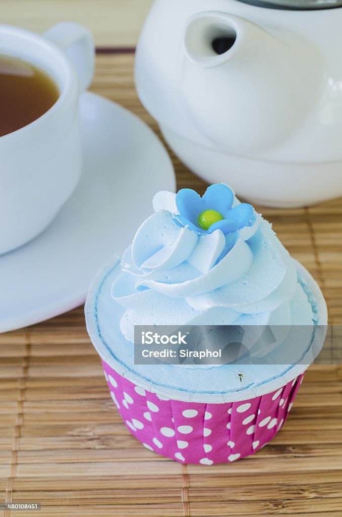Cupcake Mint cupcake on bamboo table with white tea cup&tea pot Affectionate Stock Photo