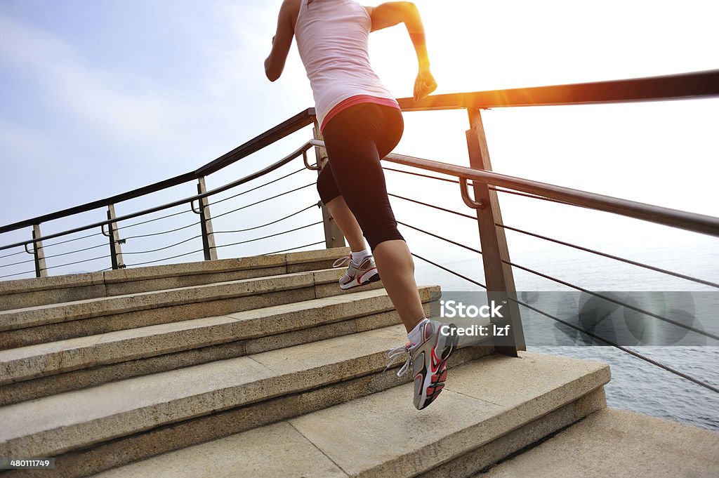 healthy lifestyle asian woman running at stone stairs seaside Running Stock Photo