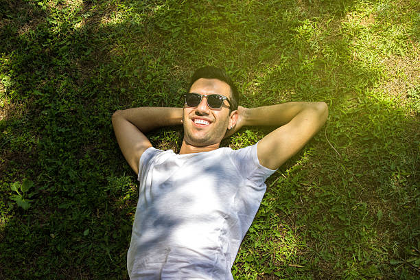 istock Portrait of a smiling young man lying on back 480112180