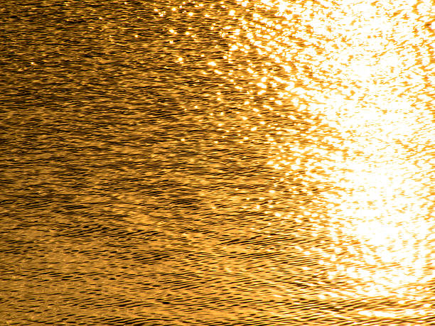 istock Golden wavelets on the surface of a water 480112497
