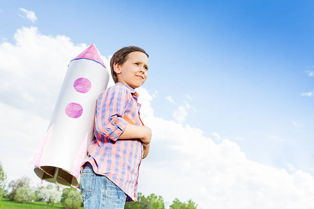 istock Looking boy wears paper rocket toy on shoulders 480113110
