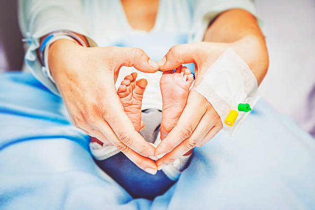 Heart Hands Feet Mothers hands and newborn feet like a heartshape in a hospital room. unknown gender stock pictures, royalty-free photos & images