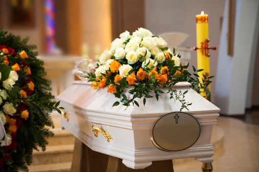 White Coffin, wreath, candle in the Catholic Church