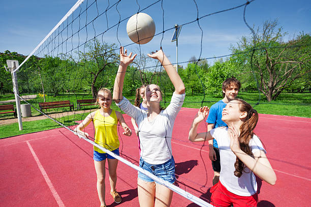 istock Teens holding arms up and playing volleyball 480115142