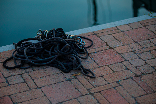 boat rope cumulated on brick way in a sea shore at sunset