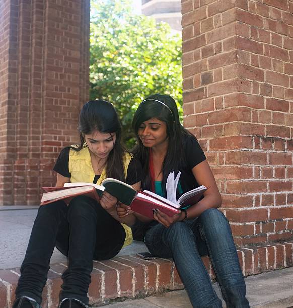 istock Two Indian / Asian college friends exchanging notes. 480119323