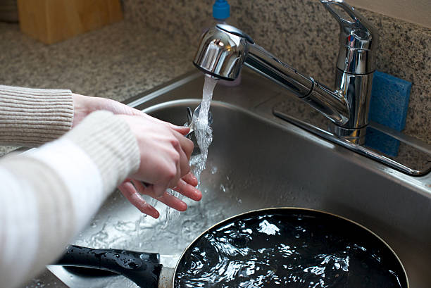 istock Close up of hands washing silverware 480120251