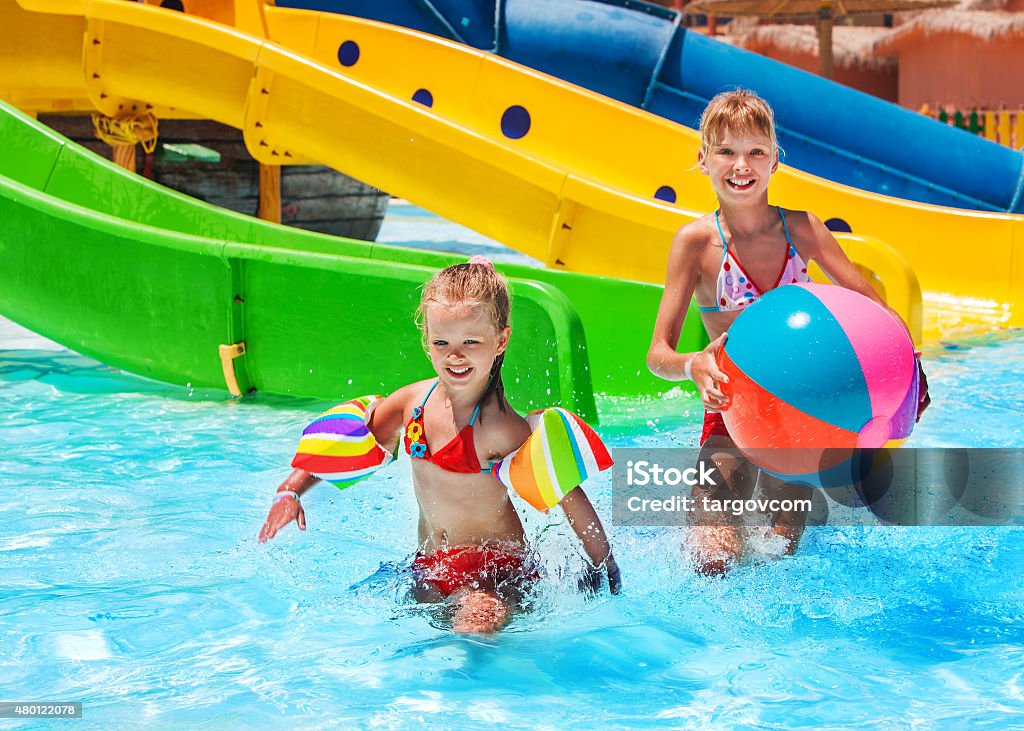Child on water slide at aquapark Child on water riding at aquapark. Summer holiday lifestyle. Water Park Stock Photo