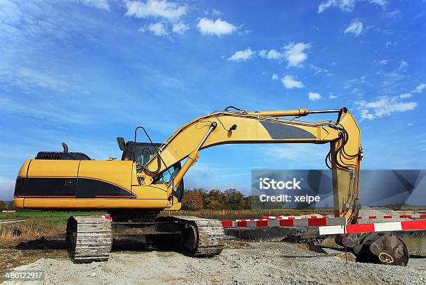 Excavator At Construction Site Digging A Hole Stock Photo - Download Image Now - Backhoe, Barricade, Construction Site