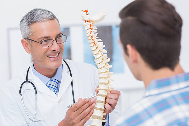 istock Doctor showing anatomical spine to his patient 480125962