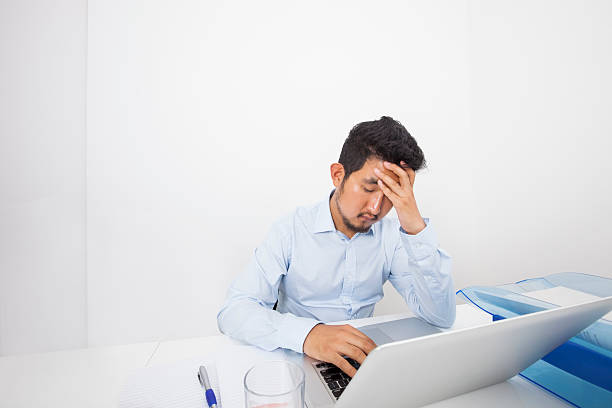 istock Stressed businessman with laptop sitting at desk in office 480129821