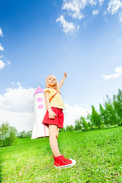 istock Girl wearing ocket toy on shoulders with arm up 480129884