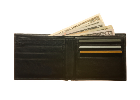 Cartera de cuero negro con notas de tarjetas de crédito y dólares photo