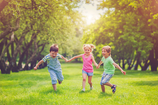 Happy children running together in park