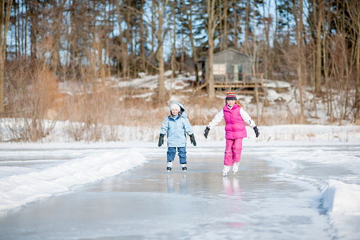 Sisters Ice Skating on Pond