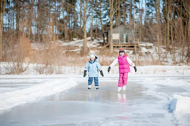 Photo of Sisters Ice Skating on Pond