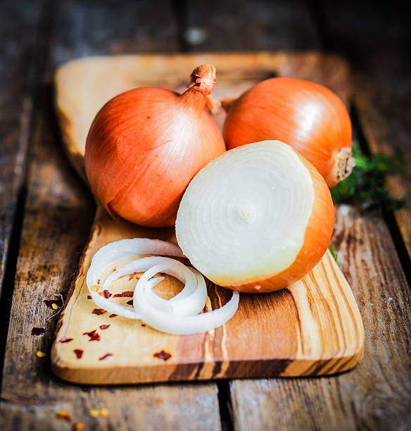 istock Golden onions on rustic wooden background 480134081