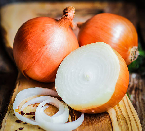 istock Golden onions on rustic wooden background 480134189