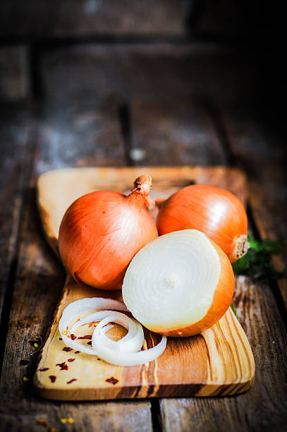 istock Golden onions on rustic wooden background 480134191