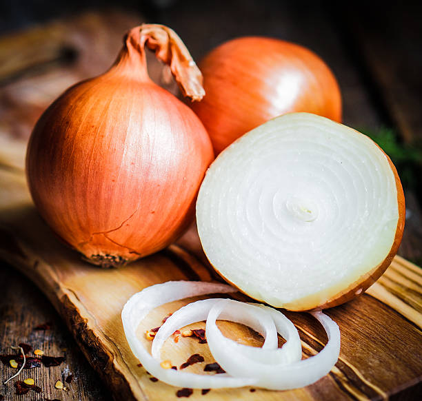 istock Golden onions on rustic wooden background 480134203