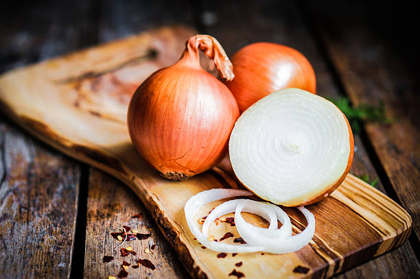 cebollas de oro sobre fondo de madera rústica - onion fotografías e imágenes de stock