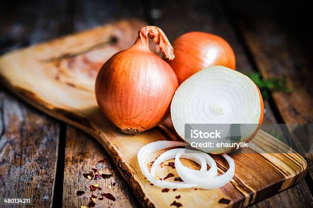 Golden Onions On Rustic Wooden Background Stockfoto en meer beelden van Ui - Ui, Geel, Snijden