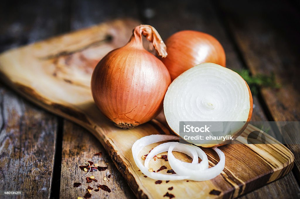 Golden onions on rustic wooden background Onion Stock Photo