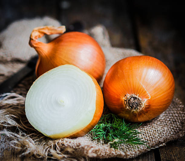 istock Golden onions on rustic wooden background 480135283