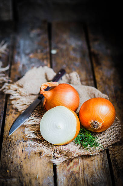 istock Golden onions on rustic wooden background 480135303