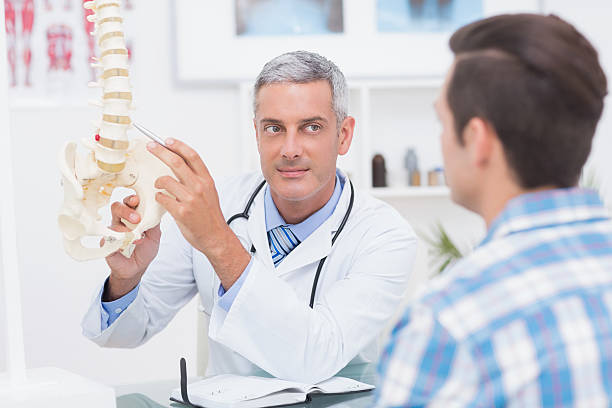 istock Doctor showing his patient a spine model 480136208