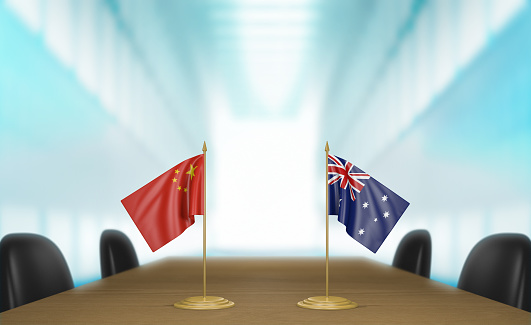 Tabletop miniature flags for China and Australia at a meeting table for diplomatic discussions and negotiations.