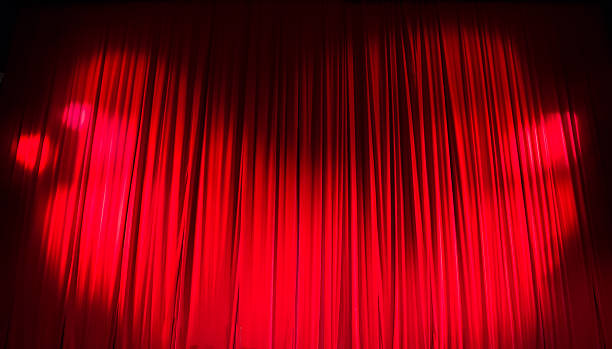 istock Red closed curtain with light spots in a theater 480137278